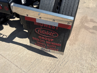 Peterbilt Group mudguard display with logos and city names on rear of a semi truck showing Peterbilt Group and 'Sioux City Des Moines Council Bluffs Norfolk Lincoln' text.