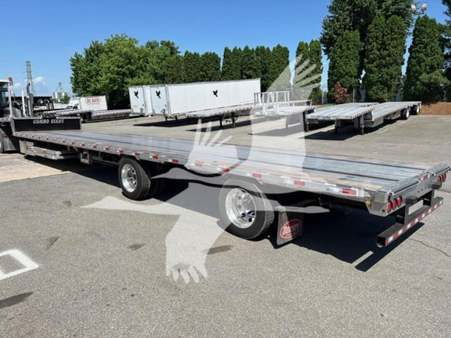 Trailer: 2027 Dorsey Combo Drop with Ramp Kit, dual-axle flatbed with metal decking and rear ramps, viewed from side/rear angle.