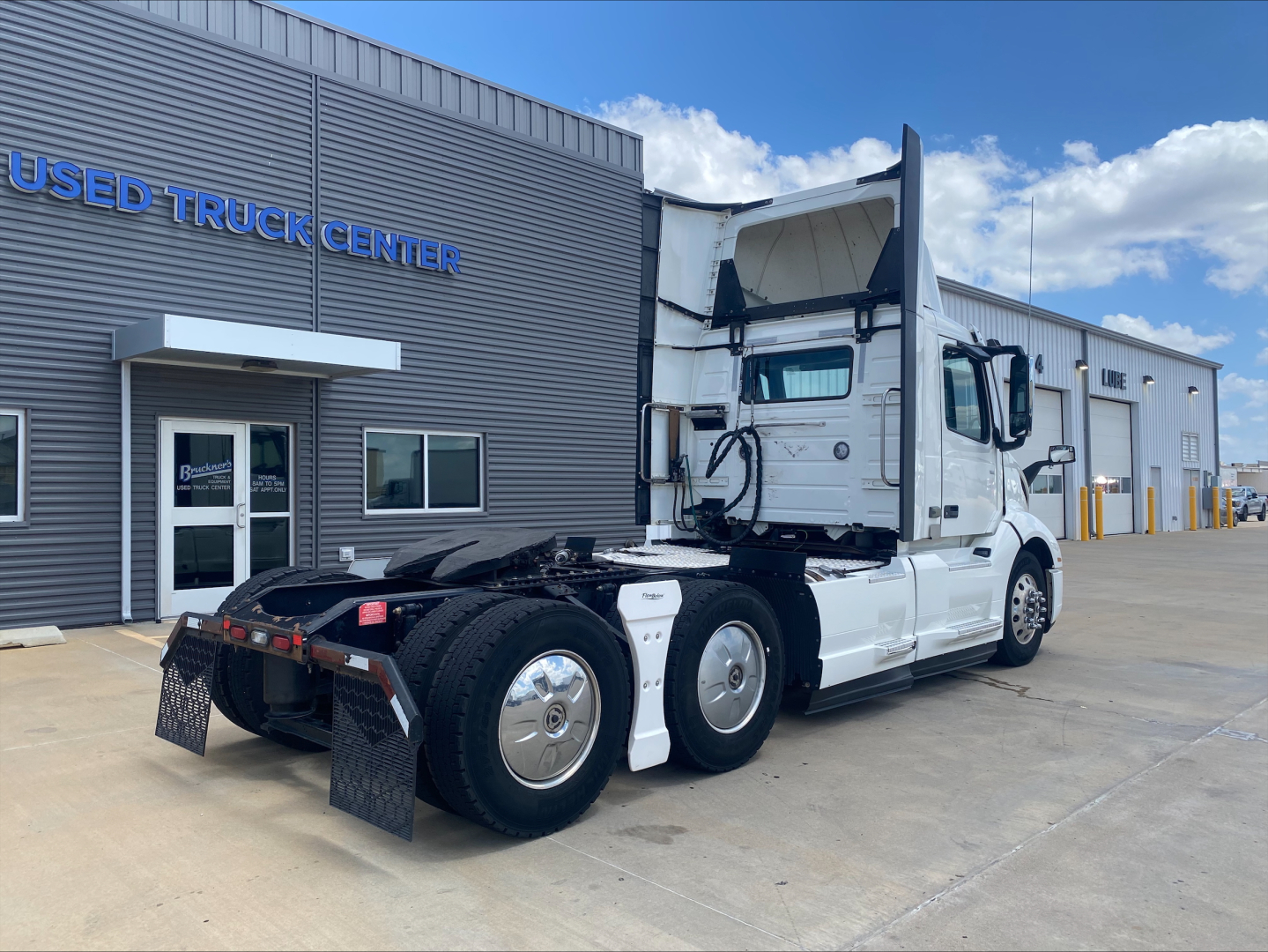 Volvo VNL300 truck in service showing daytime cab with raised sleeper and side view mirrors.