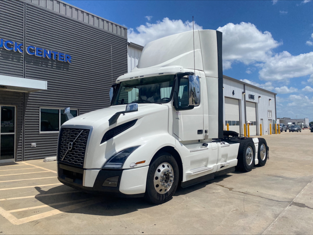 2019 Volvo VNL300 conventional daycab tractor in white, parked outside a dealership, showing Volvo grille and sleeper cab with side mirrors.