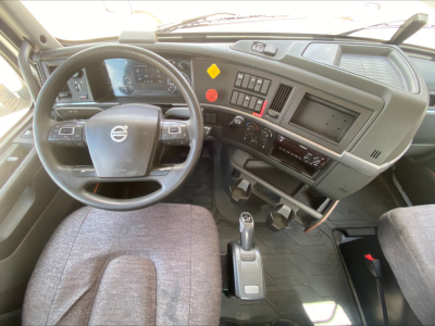 Volvo VNL300 truck cab interior with steering wheel, dashboard controls, gear shifter, and driver seat visible.