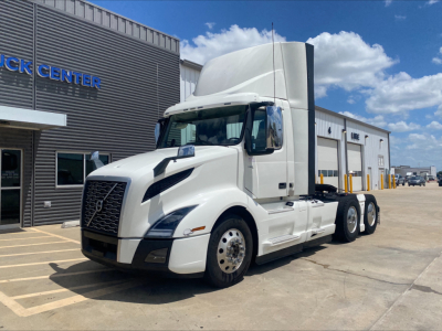 2019 Volvo VNL300 conventional daycab tractor in white, parked outside a dealership, showing Volvo grille and sleeper cab with side mirrors.