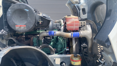 Volvo VNL300 engine bay showing coolant reservoir, hoses, and engine components in view.