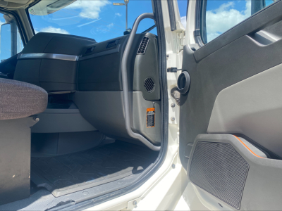 Cab interior of a 2019 Volvo VNL300 Daycab showing front seat area and open door with controls and speaker details visible.