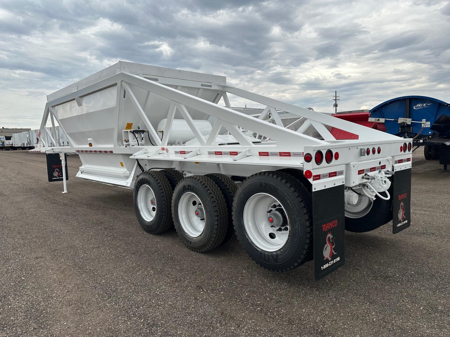 LW21-40-3 dump trailer showing white aluminum frame tri-axle with rear mud flaps and dual tandem wheels.