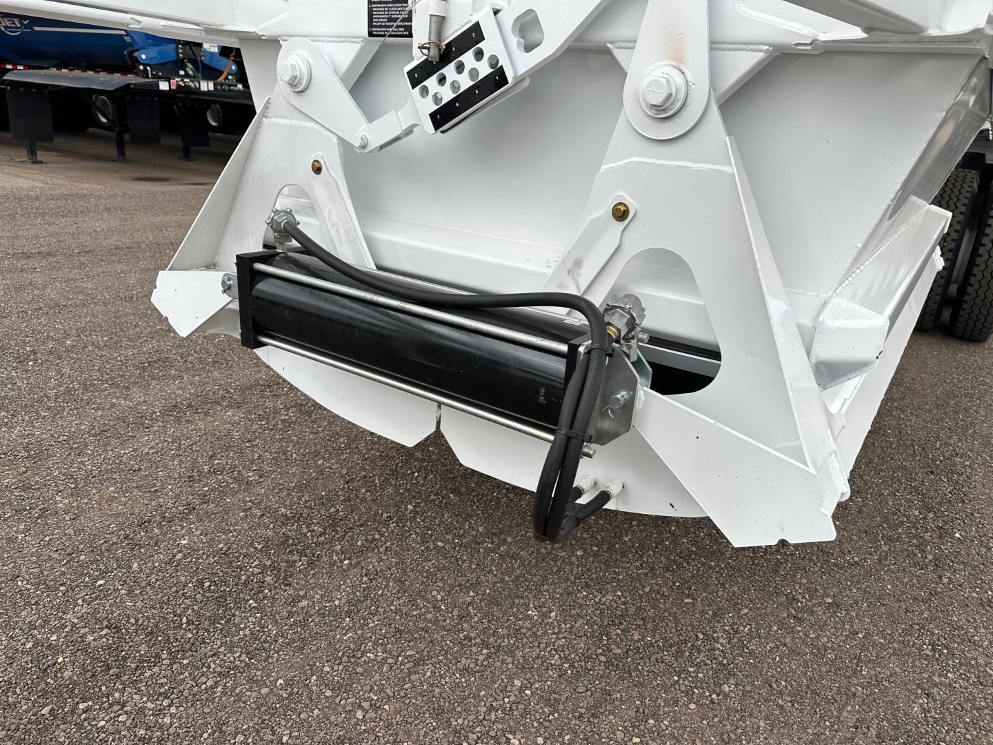 Dump trailer hitch area showing hydraulic cylinder and white reinforced frame of Ranco LW21-40-3 trailer attachment.