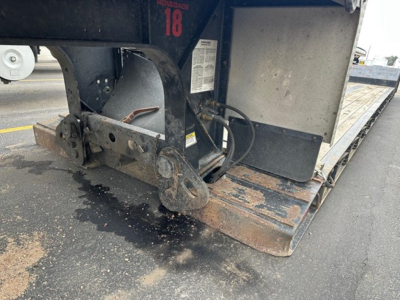 Fontaine Renegade trailer hitch area showing steel frame, ramp, and hydraulic/air lines with rusted steps and label; numeric '18' tag visible.