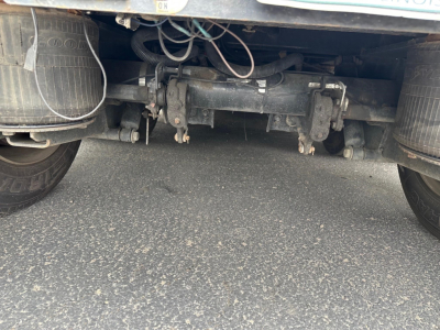 Rear view of Fontaine Renegade trailer undercarriage showing axle housing, suspension, and various hoses and connectors.