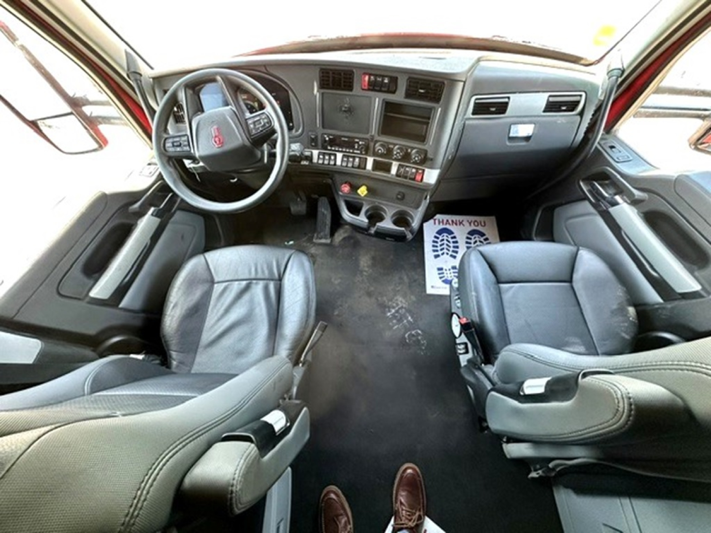 Kenworth T680 truck cabin interior view showing steering wheel, dashboard, seats, and central control panel.