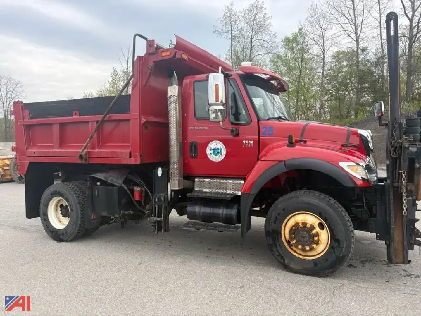 International WorkStar 7500 dump truck with plow, wing, and sander in red side view showing front axle.