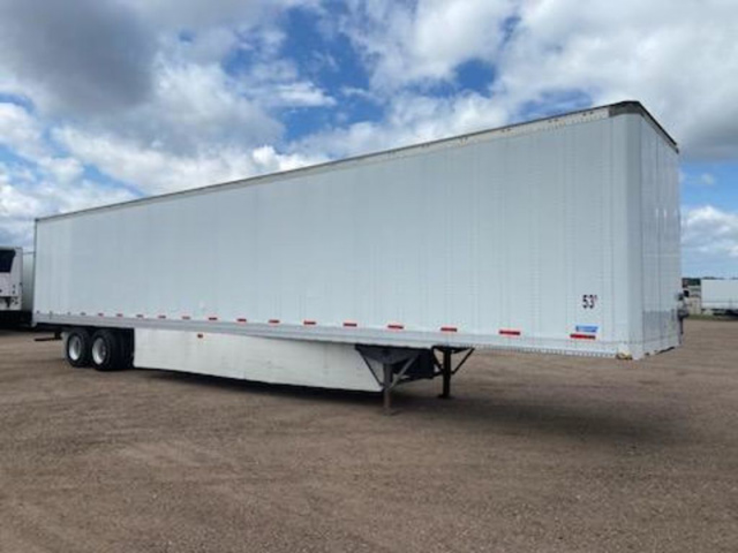 Trailer side view showing a white 2014 Stoughton van trailer with triple-axle rear and support legs, 53’ height marker, and blue/red stripe decals.
