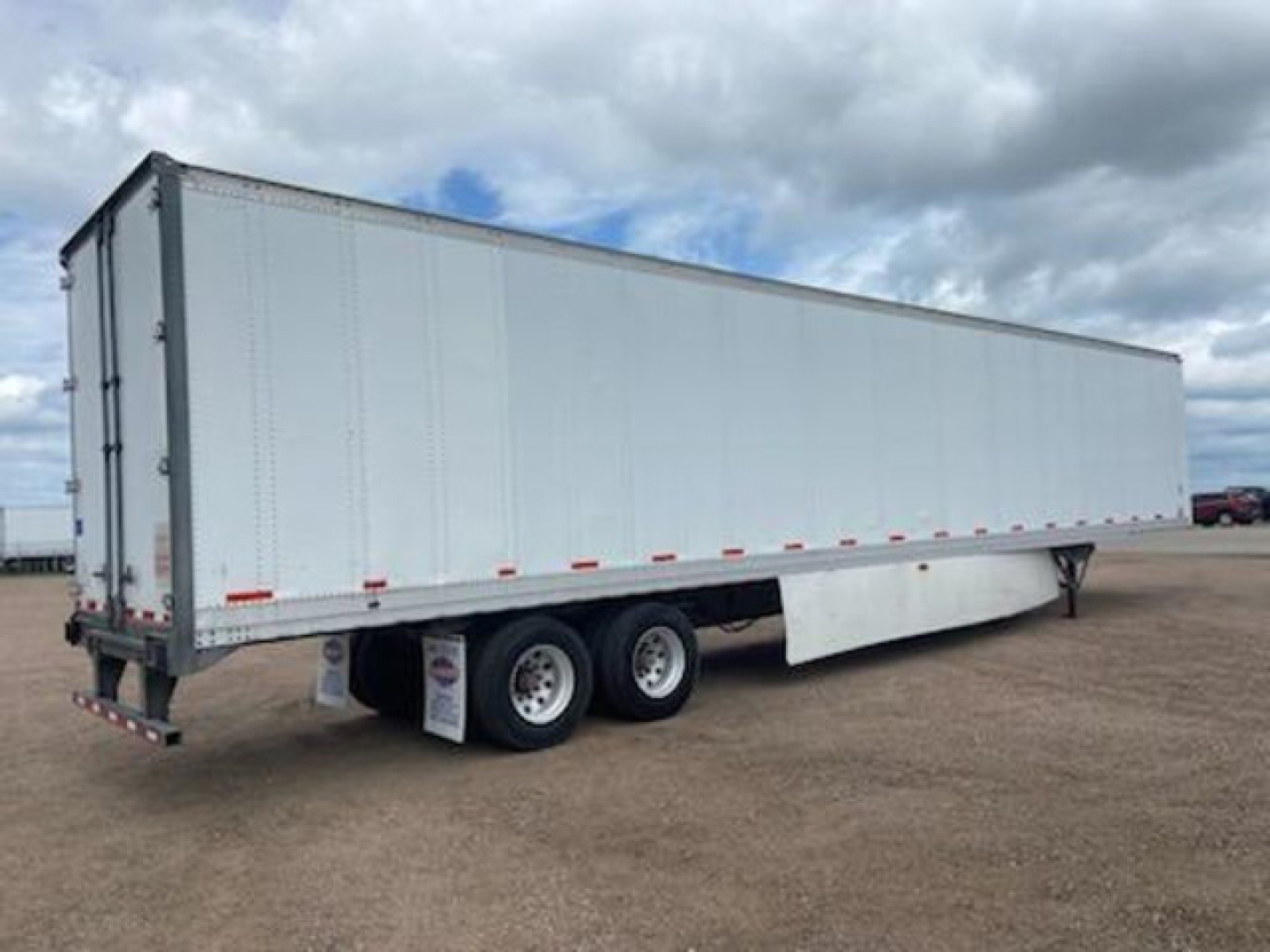 Trailer side view: 2014 Stoughton van trailer with tandem axles, white exterior, no visible branding.