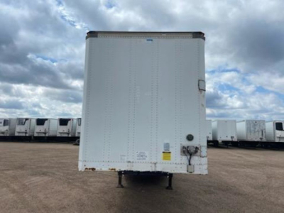 Trailer rear of a 2014 Stoughton van with raised cargo area, white exterior, rear doors, and standard undercarriage in a lot with other trailers.