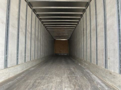 Trailer interior with wooden rear wall showing empty cargo area inside a Stoughton van trailer.