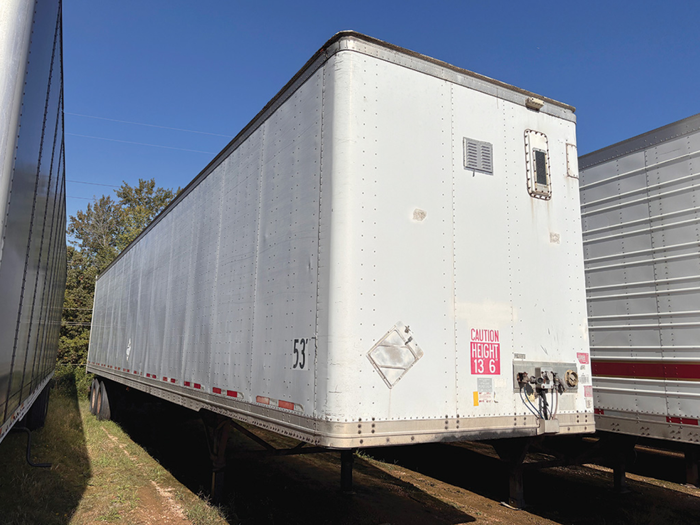 Wabash aluminum dry van trailer viewed from rear-left side showing exterior panels, rear doors, and weight/sticker placard.