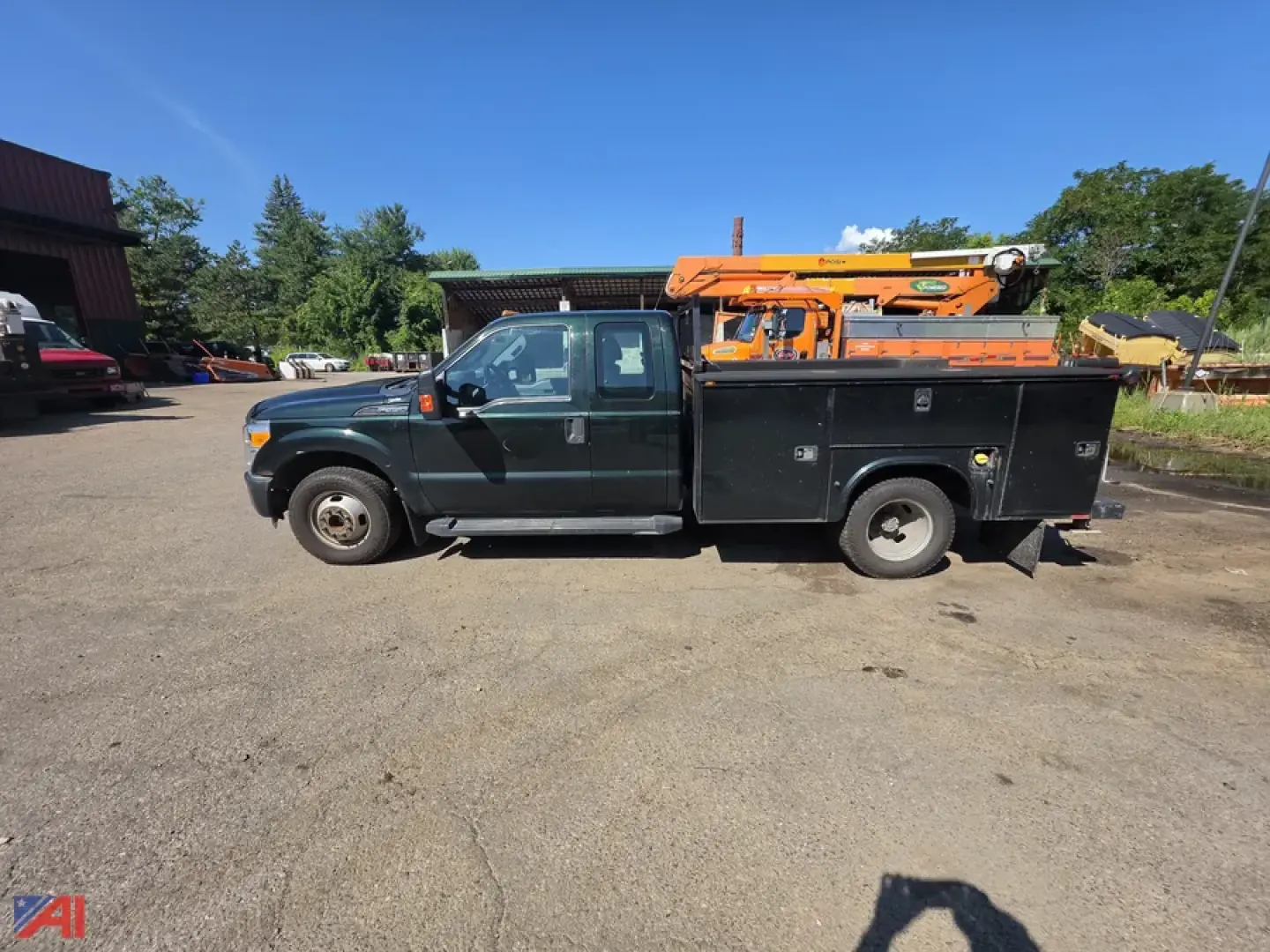 Ford F-350 Super Duty utility service truck side view showing utility bed with compartments and an orange crane on top.