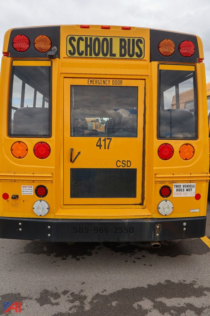 Rear view of a yellow Ford Blue Bird school bus showing emergency exit door and rear lights.