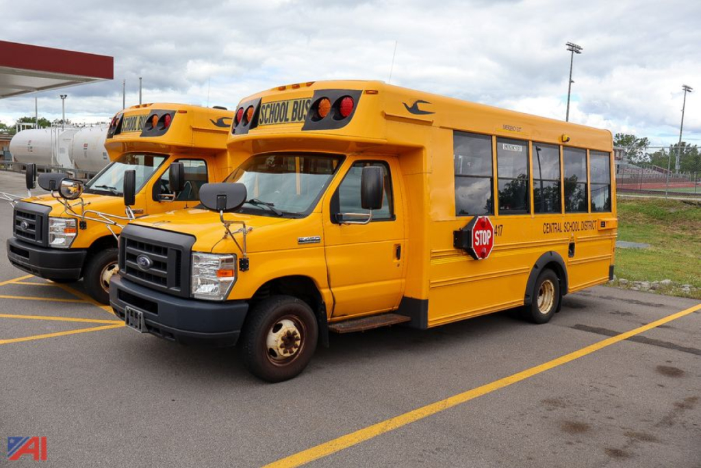 Ford Blue Bird school bus from side and front angle showing yellow school bus with stop sign extended and school bus markings.