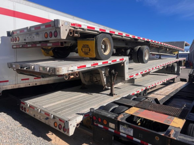 Trail King TK80Acs-34 trailer combination showing flatbed trailer with dual rear axles and spare wheel, stacked on a lowboy.
