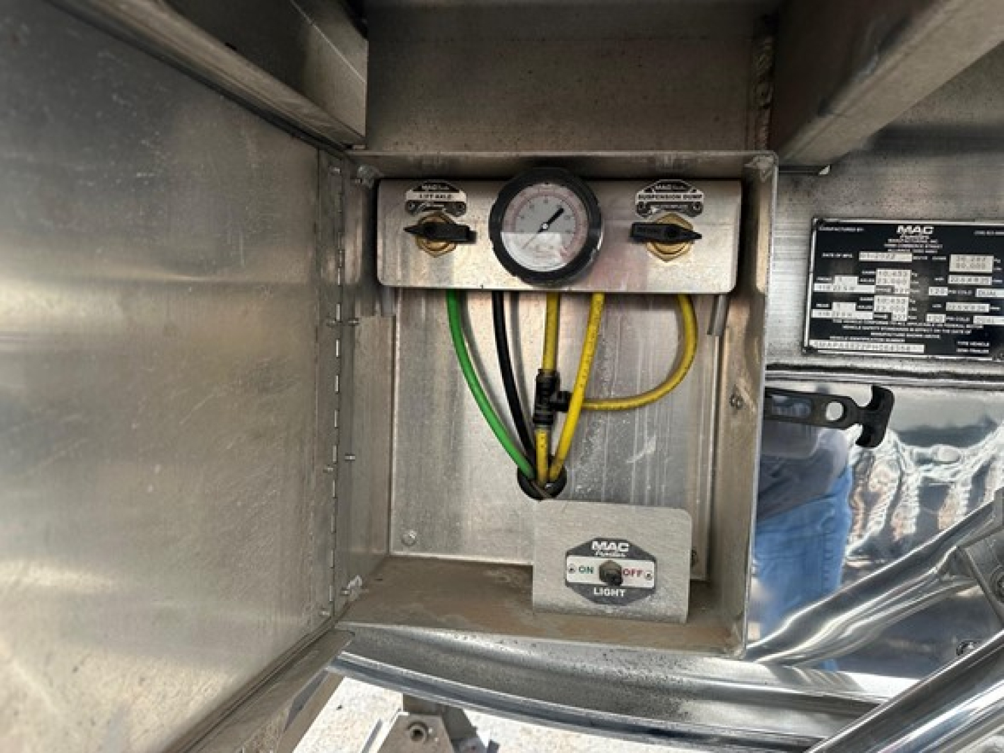 Mac polished all aluminum flatbed lift trailer control panel with gauge and wiring inside metal enclosure showing MAC label and ON/OFF light switch.