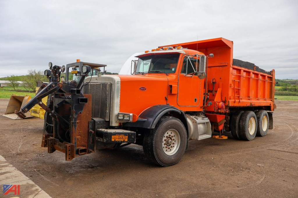 Peterbilt 357 dump truck with plow attachment in orange and white cab, residential front plow and large orange dump bed.