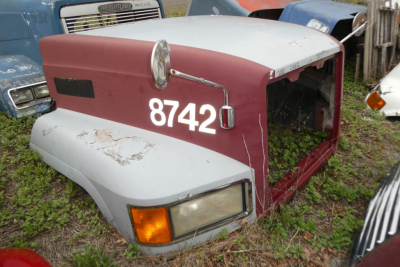 Mack CH612 hood/front section showing maroon and gray paint with large white '8742' number, headlight, and side mirror.