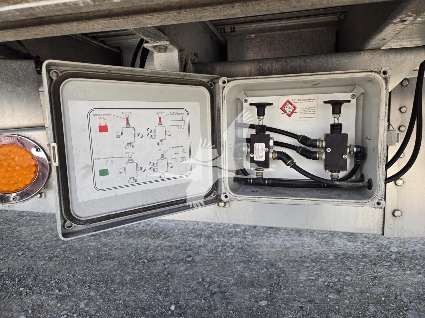 Trailer utility panel open showing hydraulic/electrical fittings and schematic diagram inside door panel on a 2019 Reitnouer dropdeck trailer.