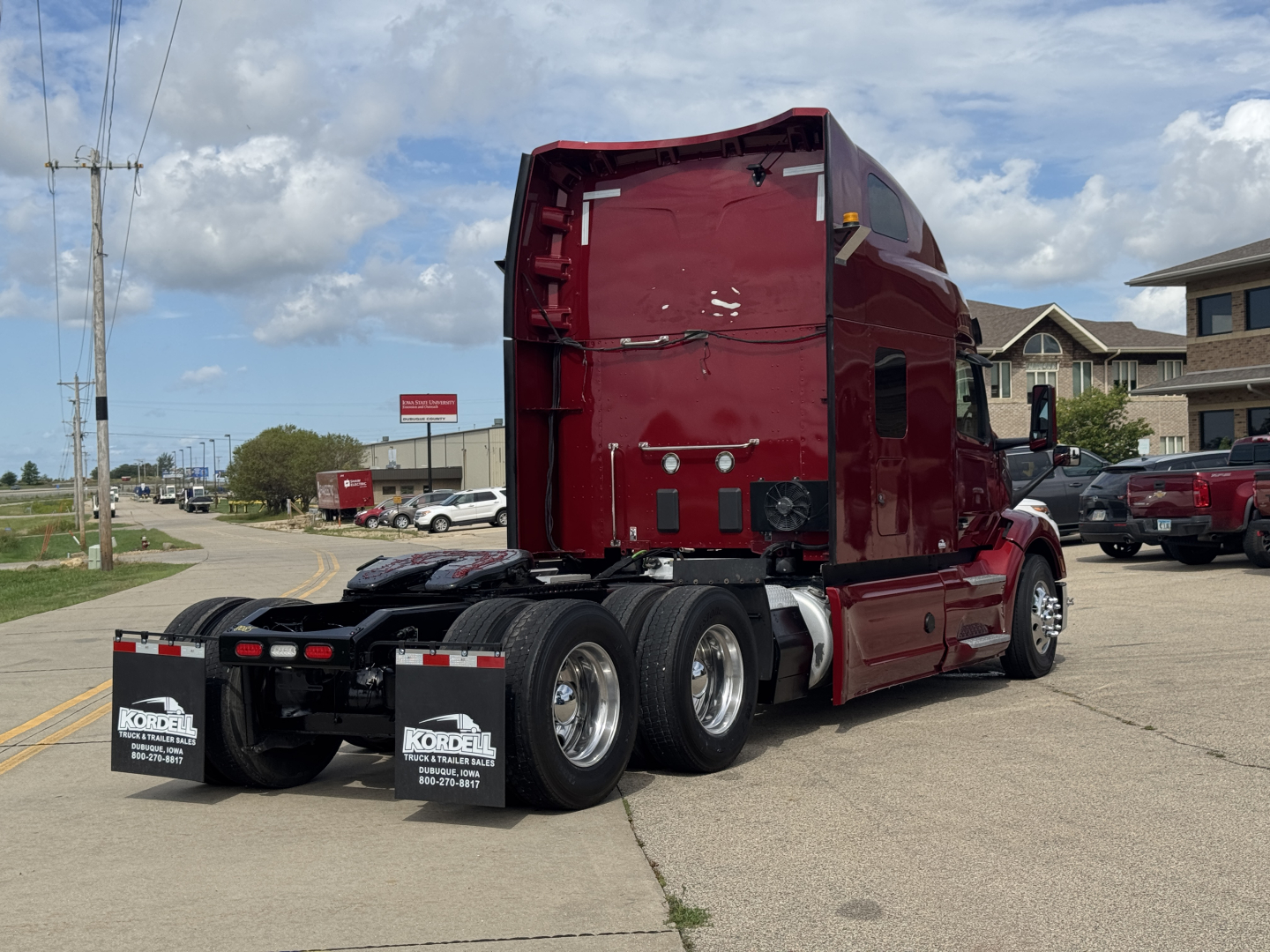 Peterbilt 579 conventional sleeper truck rear three-quarter view showing dual rear axles and red cab with APU area.