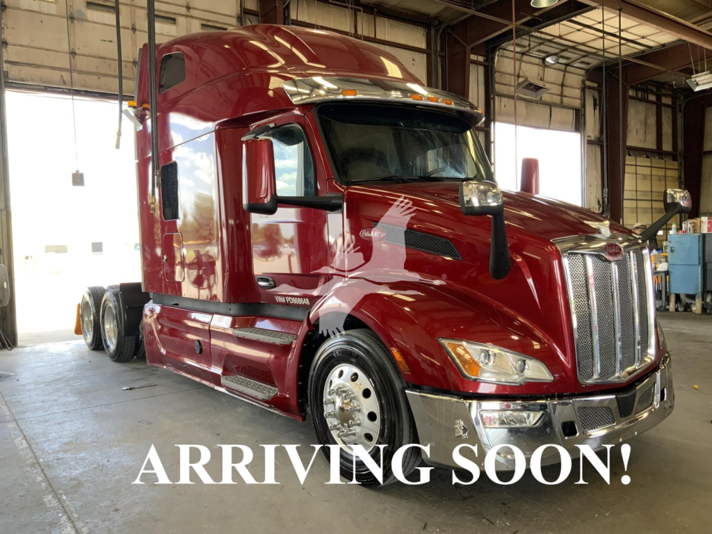 Peterbilt 579 truck in a workshop, maroon color, cabover with chrome grille and side mirrors, text overlay 'ARRIVING SOON!'