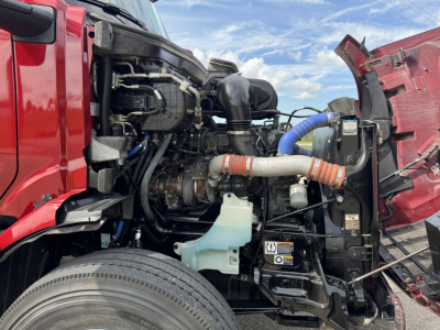 Peterbilt 579 engine bay showing coolant reservoir, hoses, and intake components with open hood.