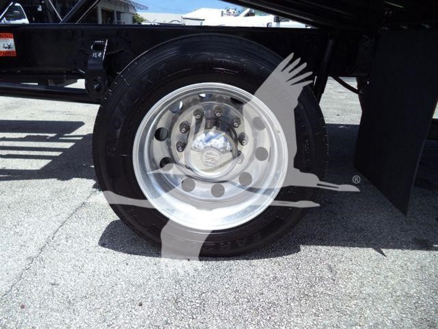 Truck rear wheel showing polished steel rim and tire on a Hino 268A rollback truck with stock number T75219FM.