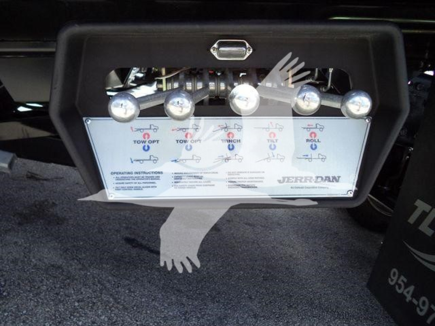 Hino 268A rollback control panel with multiple levers for towing operations and an instructional label showing operating instructions and labels.
