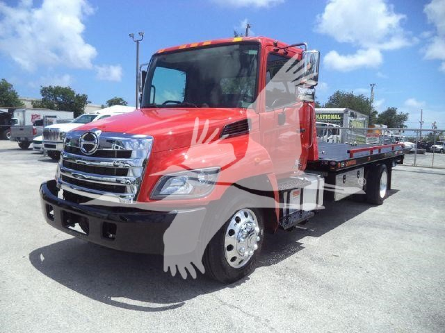 Truck side view showing red 2020 Hino 268A rollback tow truck with flatbed, chrome grille, and dual rear axles.