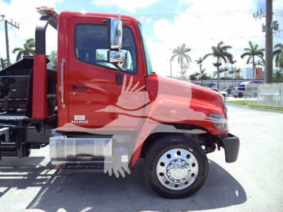 Red 2020 Hino 268A rollback truck side view showing cab and front wheel.