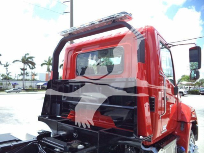 Truck cab rear view of a red 2020 Hino 268A rollback truck showing cab, rear window, and body-mounted equipment.