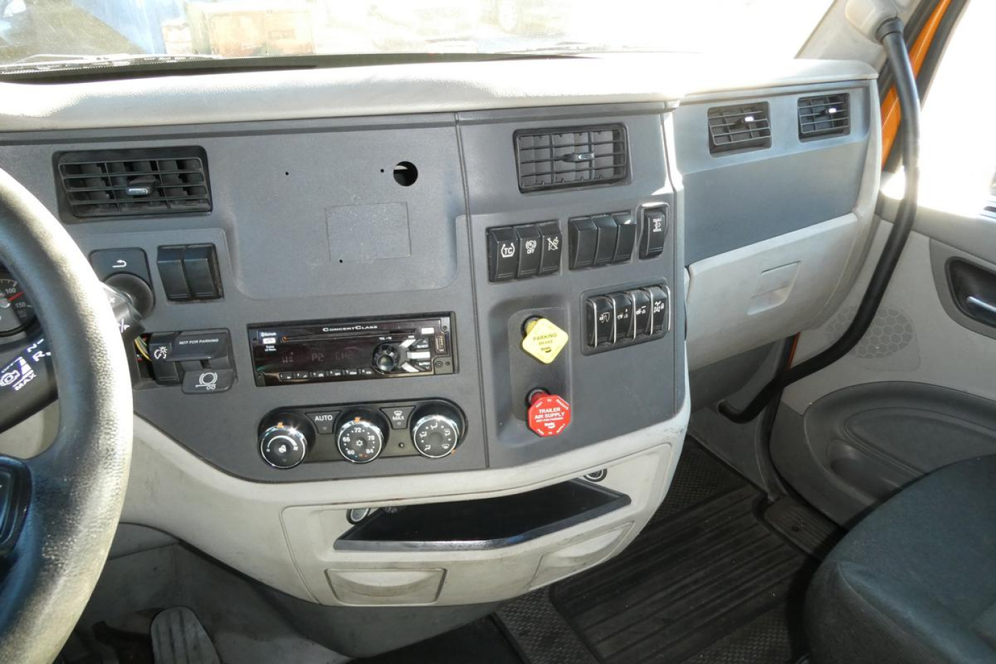 Peterbilt 579 truck cab interior dashboard view showing steering wheel, control panel, air vents, switches, and gear area.