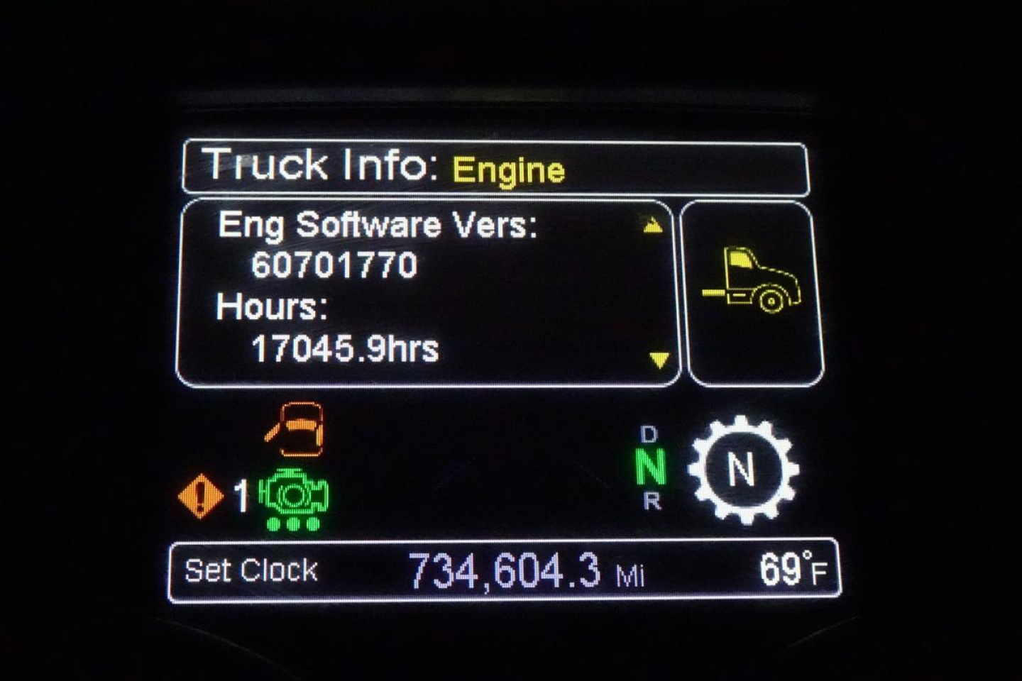 Truck info screen showing Engine Software Version 60701770, hours 17045.9, set clock 734,604.3 mi, ambient 69°F, gear indicator N, warning icons.