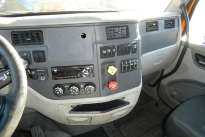 Peterbilt 579 truck cab interior dashboard view showing steering wheel, control panel, air vents, switches, and gear area.