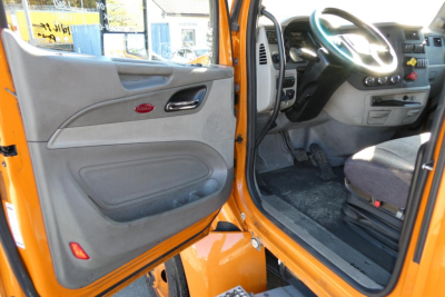 Peterbilt 579 truck cab interior door and steering wheel view showing dashboard and driver seat area.