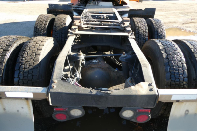 Peterbilt 579 truck chassis rear view showing dual rear axles and fifth wheel mount, metal frame, and dual sets of tires.