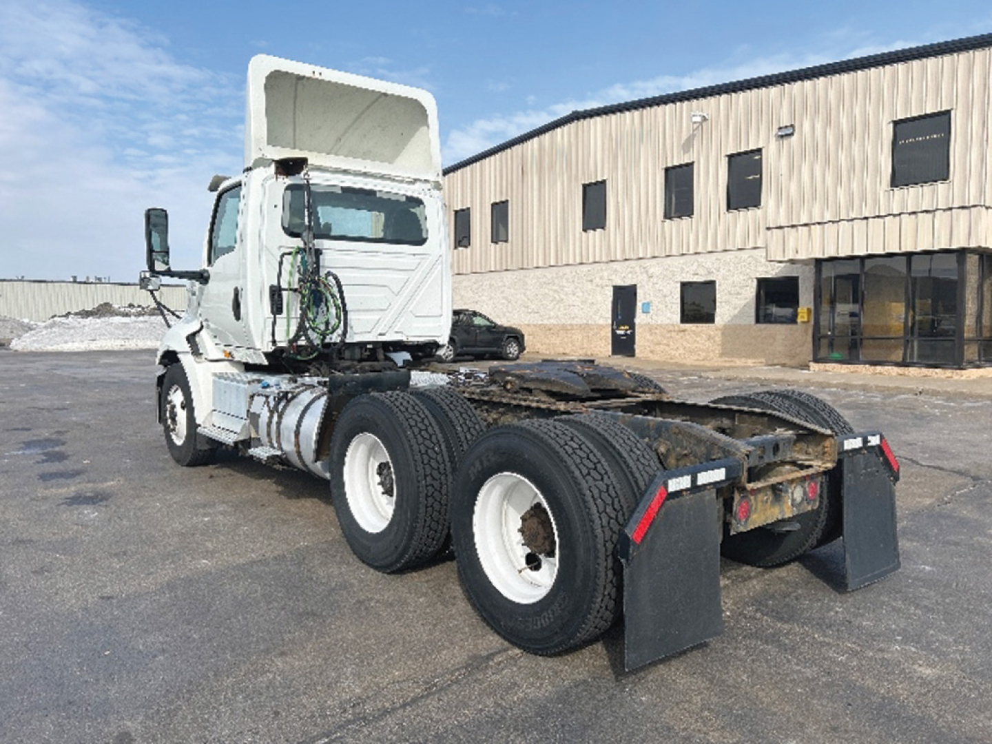 Truck chassis and cab of a 2018 International RH613 from rear three-quarter view, showing dual rear axles and hitch area.