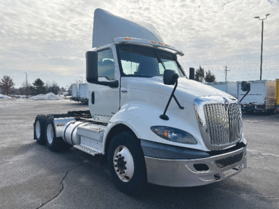 International RH613 truck in daylight showing cab and chassis with 6 wheels, front grille, and side mirrors.