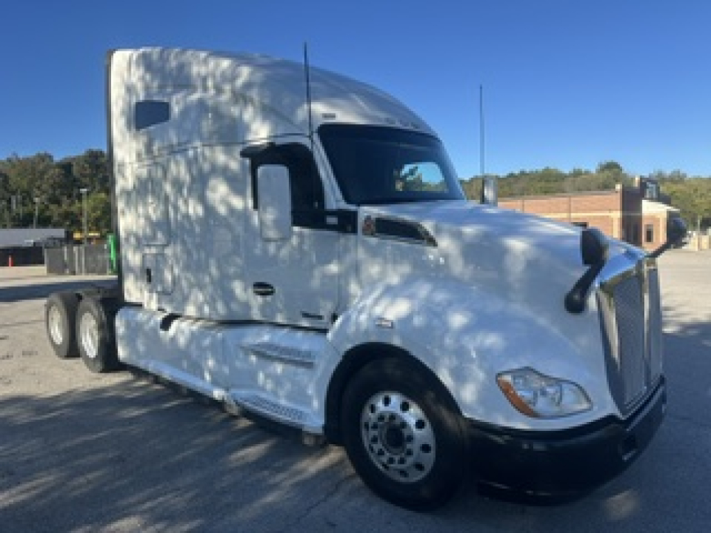Kenworth T680 tractor cab in white, side view showing sleeper, front bumper, and wheels.