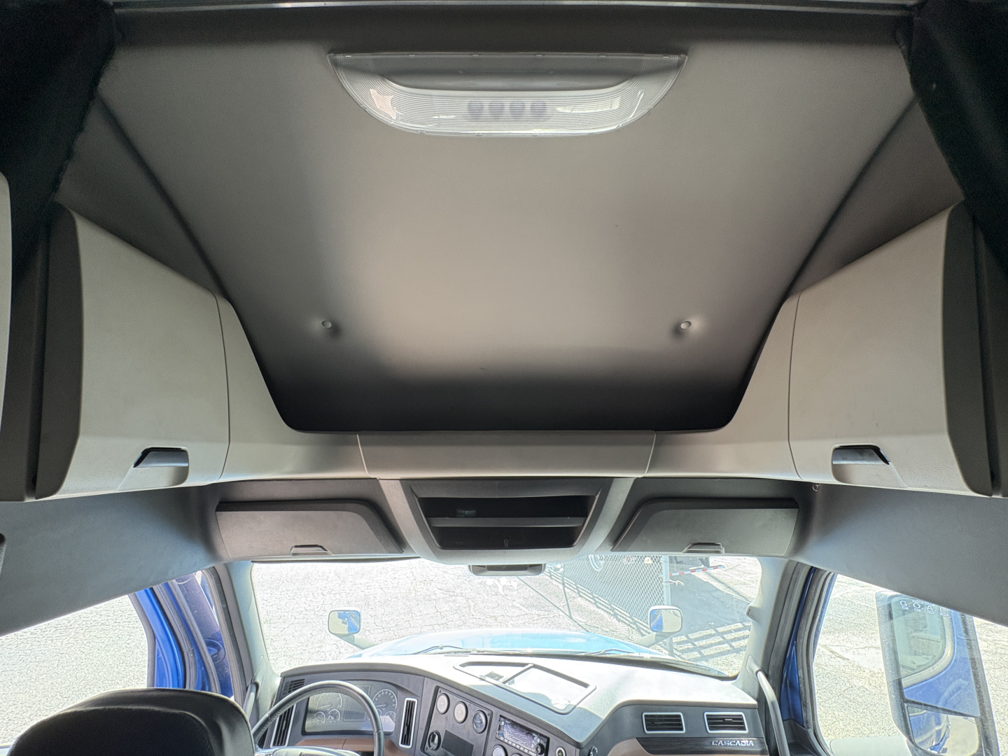 Cab interior of a 2022 Freightliner Cascadia 126 truck showing overhead console and sun visor area.