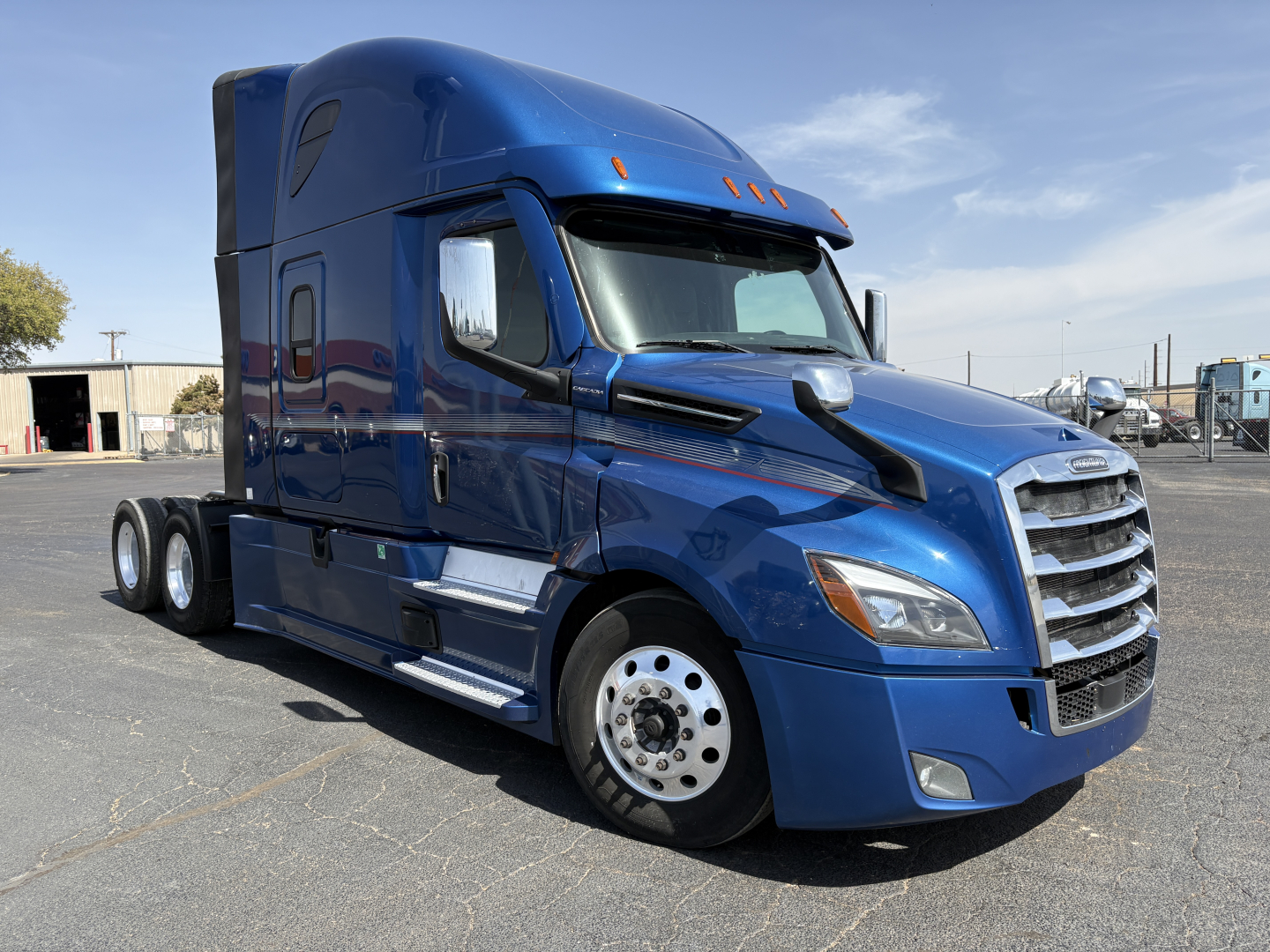 Freightliner Cascadia 126 sleeper tractor truck in blue, side view showing chrome grille and dual rear axles.
