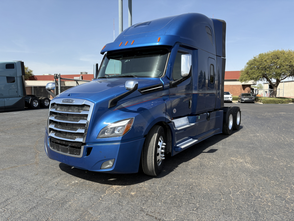 Blue Freightliner Cascadia 126 sleeper cab front-left view with chrome grille, stacked headlights, and aerodynamic mirrors.