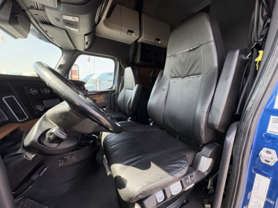 Freightliner Cascadia 126 cab interior showing driver's seat and dashboard with steering wheel and overhead storage