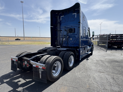 Truck cab of a 2022 Freightliner Cascadia 126 tractor from rear-left angle, showing dual rear axles and back of cab.