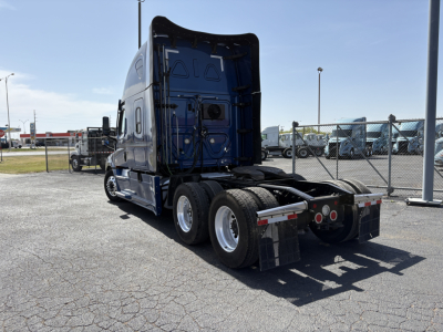 Freightliner Cascadia 126 tractor in blue, rear view showing fifth wheel and dual rear axles in a used trucks lot.