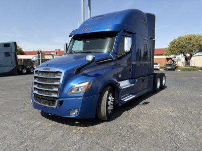 Blue Freightliner Cascadia 126 sleeper cab front-left view with chrome grille, stacked headlights, and aerodynamic mirrors.